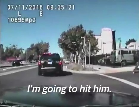 It is unclear in the video whether that same officer, or his partner, then says “I’m going to hit him.”