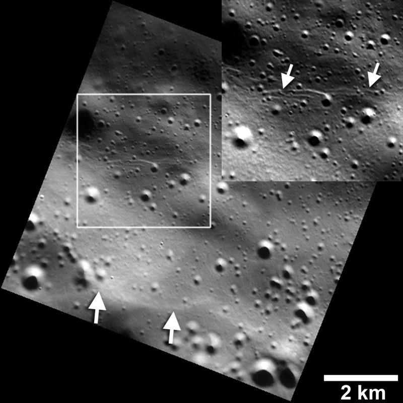 Small graben, or narrow linear troughs, have been found associated with small fault scarps (lower white arrows) on Mercury, and on Earth’s moon. The small troughs, only tens of meters wide (inset box and upper white arrows), likely resulted from the bending of the crust as it was uplifted, and must be very young to survive continuous meteoroid bombardment. Image via NASA/JHUAPL/Carnegie Institution of Washington/Smithsonian Institution