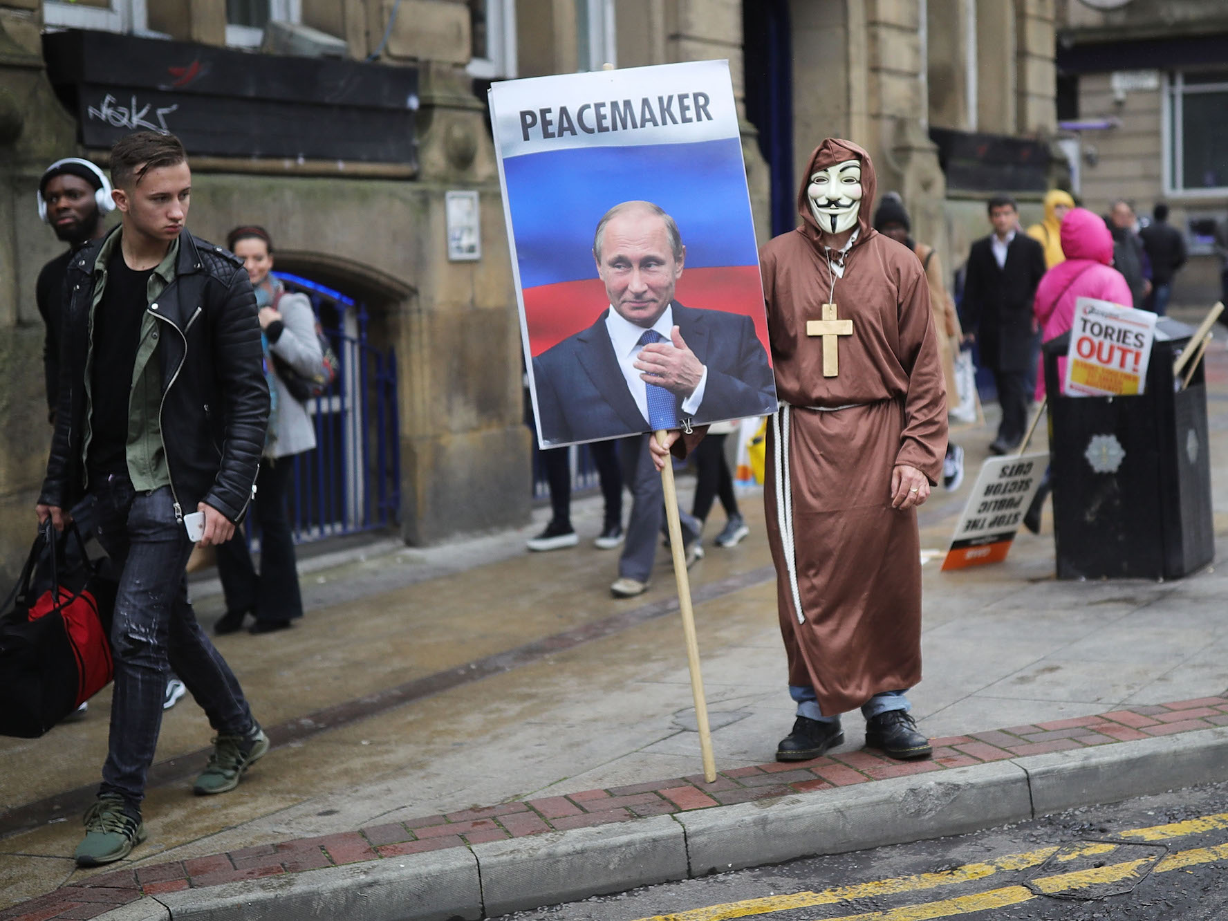 A man dressed up in a mask and holding a sign with Vladimir Putin on it saying 'Peacemaker' takes part in anti-Brexit and anti-austerity protests as the Conservative party annual conference gets underway at Manchester Central on October 1, 2017 in Manchester, England. Five-hundred thousand people are expected to take part in the protests with police mounting an unprecedented security operation of a thousand officers and extra armed police to protect Conservative party conference delegates. (Photo by Christopher Furlong/Getty Images)