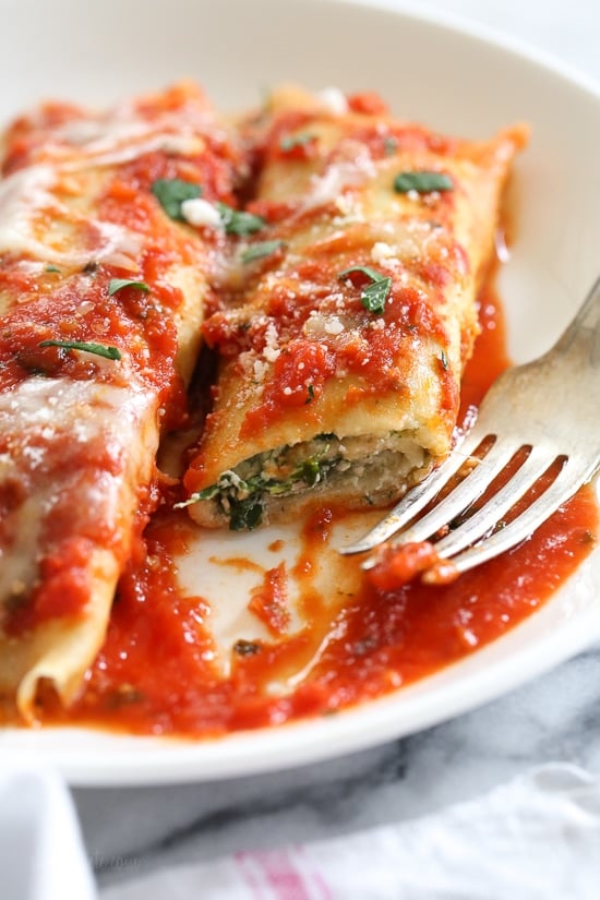 The secret to the best, irresistible manicotti is to make them from scratch with my easy homemade crespelles, which are basically Italian crepes. These spinach and cheese manicotti are filled with three cheeses – ricotta, mozzarella and parmesan, then topped with homemade sauce. So damn delicious!