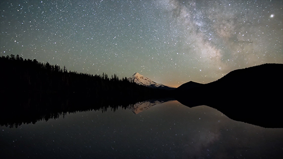 mountain and stars reflected in water