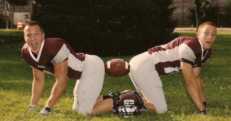 cringey senior photo of two football players pretending a football is a dildo - cover image for a list of cringey senior photos