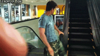 guy spins on escalator rails