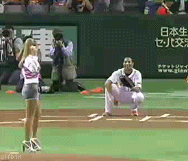 girl throws out the first pitch at a baseball game and throws it straight into the ground