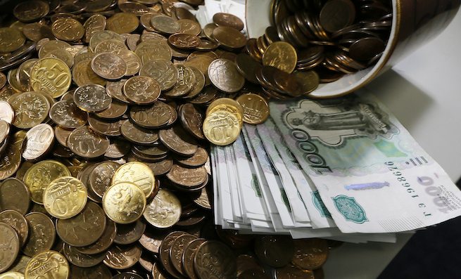 Russian 1000-rouble banknotes, 50 and 10 kopeck coins are seen on a table at a private company's office in Krasnoyarsk, Siberia November 6, 2014. The rouble briefly weakened to a new all-time low of over 46 roubles per dollar on the Moscow Exchange on Thursday, extending losses from earlier in the session to trade over 2 percent lower than the previous close. REUTERS/Ilya Naymushin (RUSSIA - Tags: BUSINESS)
