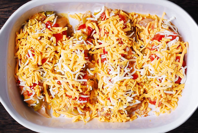 Top Queso smothered chicken with cheese in a baking dish