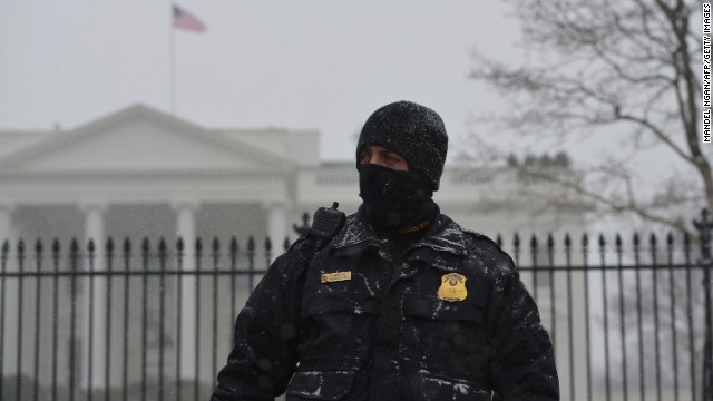 A member of the Secret Service Uniform Division stands guard in front of the White House as snow falls in Washington on January 21.