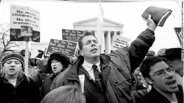 The Rev. Flip Benham, director of Operation Rescue National from Dallas, prays, sings and hoists his Bible over his head in front of the Supreme Court at the tail end of the March For Life march.