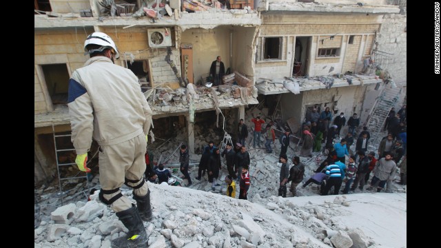Residents search for survivors in Aleppo on Saturday, December 28, after what activists said were airstrikes by forces loyal to Syrian President Bashar al-Assad. 