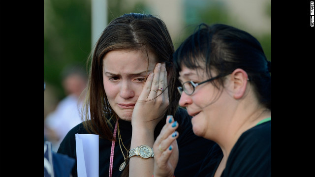 Dara Anderson, left, and Monique Anderson cry during a candlelight vigil across the street from the crime scene.
