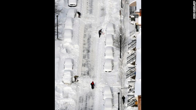 People dig out vehicles buried in snow in Albany, New York, on February 14.