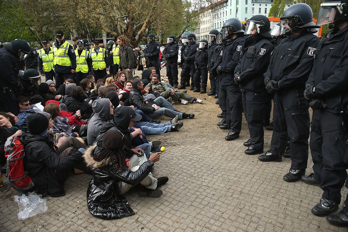 Riot police confront protesters at the former temporary refugee camp