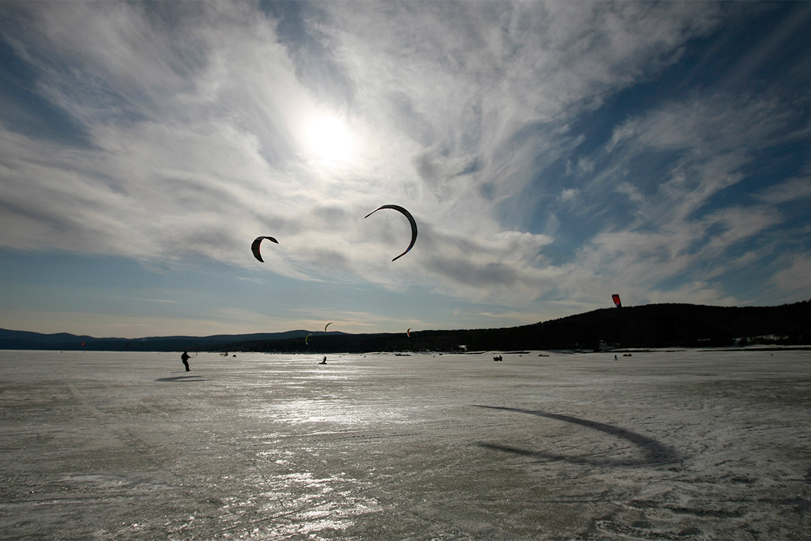 Kite boarders and kite skiers compete during an amateur regional competition on the frozen Yenisei River in the Taiga district outside Russia's Siberian city of Krasnoyarsk
