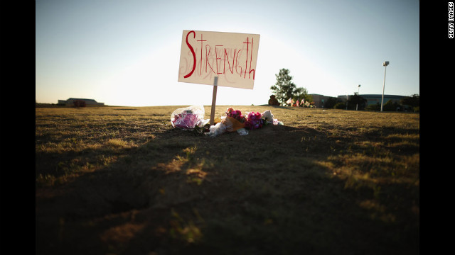 Handwritten signs decorate the makeshift memorial across from the Century 16 movie theater on Saturday.