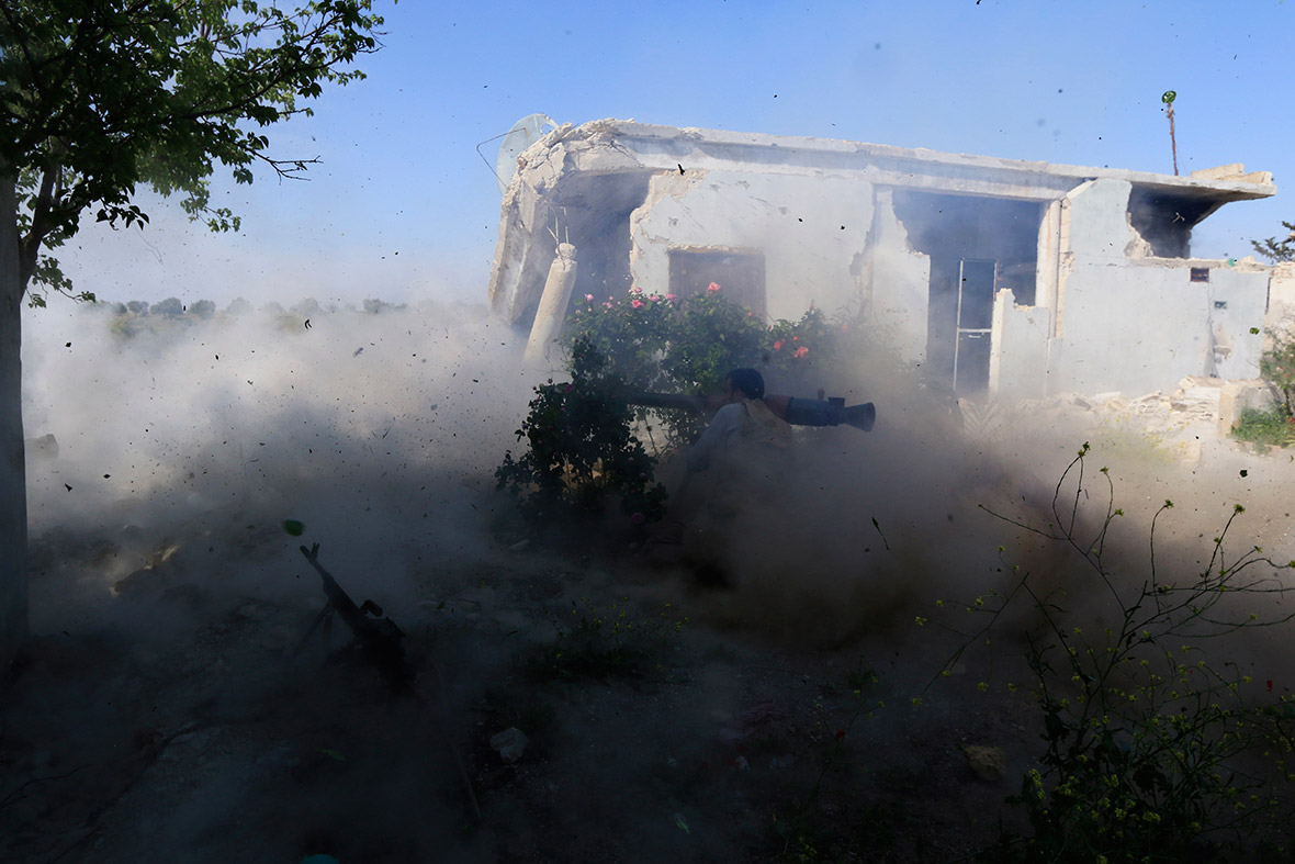 A rebel fighter launches a rocket towards a post occupied by forces loyal to Syria's President Bashar al-Assad near Idlib