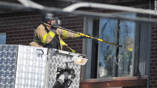 Police break a window at the suspect's apartment Friday in Aurora.