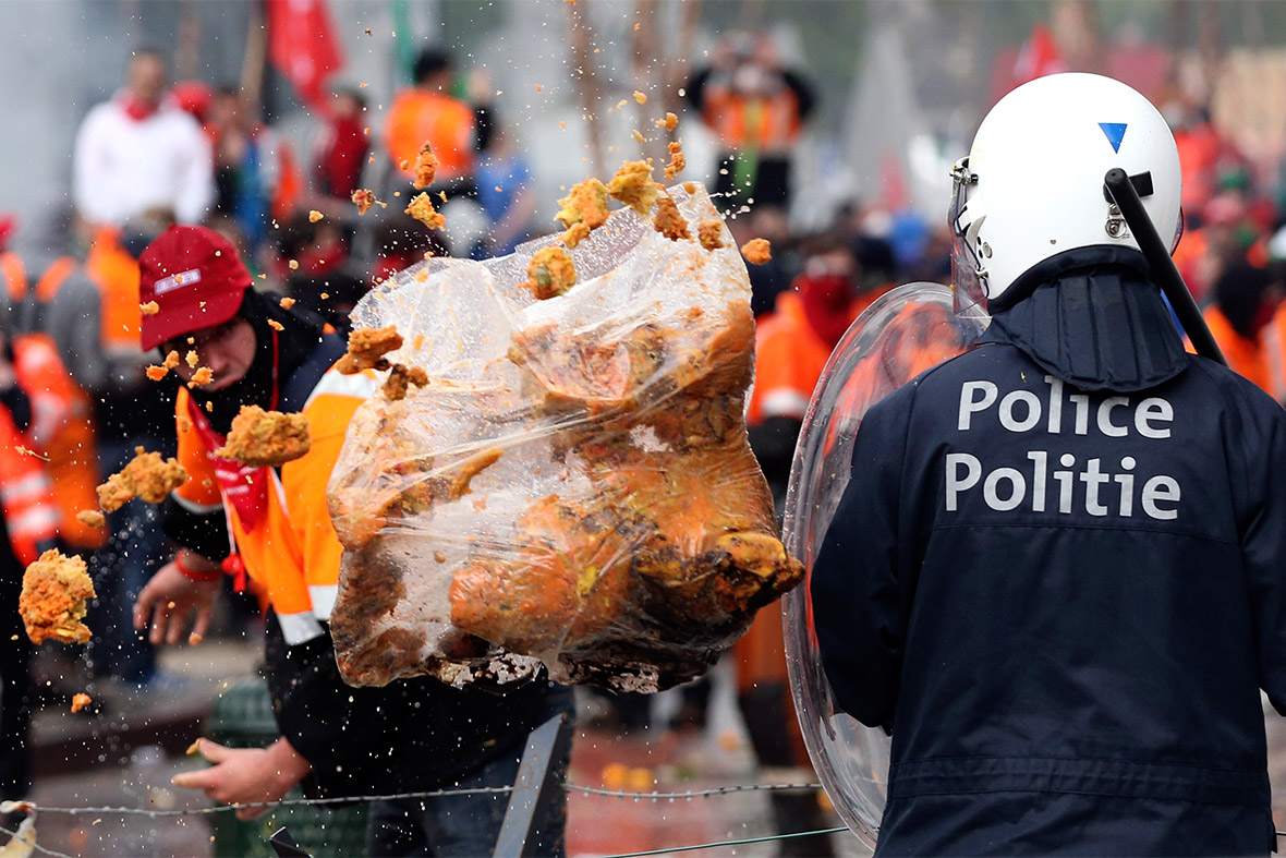 A bag of rubbish bursts as a demonstrator throws it towards riot police during a European trade unions protest against austerity measures in Brussels