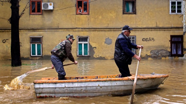Men paddle through the flooded streets of Obrenovac, Serbia, on Friday, May 16. Authorities estimate that 90% of the town has been flooded.