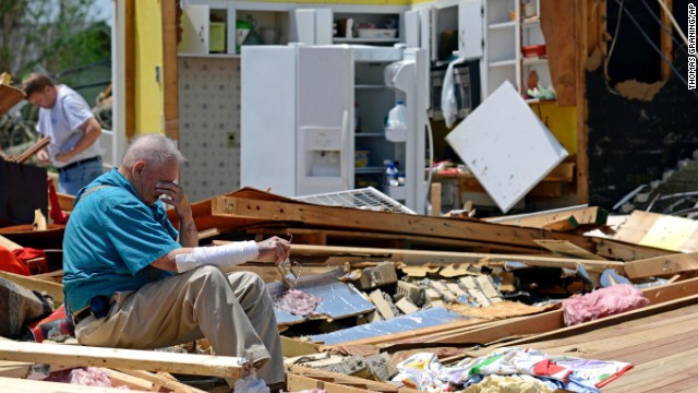Charles Milam takes a break while searching his destroyed home in Tupelo on Tuesday, April 29.