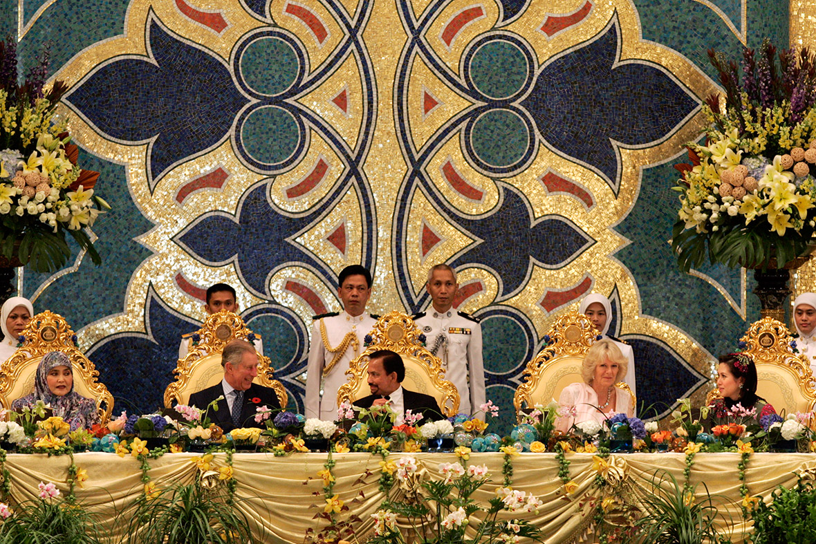 October 31, 2008: The Sultan of Sultan Hassanal Bolkiah talks to Prince Charles as Camilla, talks to the Sultan's second wife, Azrinaz Mazhar Hakim,. His first wife Queen Saleha sits next to Charles during a royal banquet at the Nurul Iman Palace in Bandar Seri Begawan