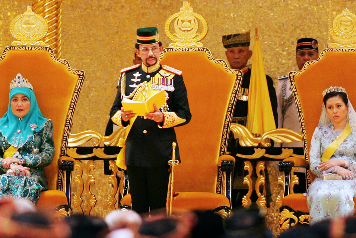 July 15, 2006: Brunei's Sultan Hassanal Bolkiah, flanked by his first wife Queen Saleha and second wife Azrinaz Mazhar Hakim, delivers a speech during his 60th birthday celebrations