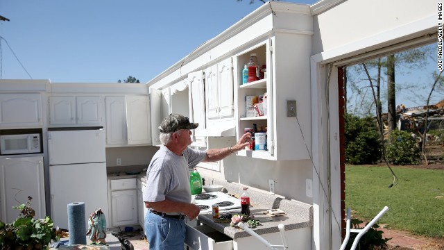 Jerry Estes salvages food items April 30 from the kitchen of his home that was damaged on by a tornado in Louisville, Mississippi.