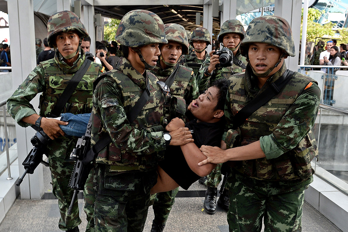 Thai soldiers remove an anti-coup protester from the site of a gathering in Bangkok