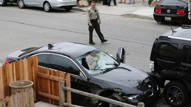 A Santa Barbara County deputy sheriff checks out the black BMW sedan driven by the suspected shooter. The gunman died from a gunshot wound after his car crashed, police said. It was unclear whether the fatal head wound was self-inflicted or the result of a firefight with police.