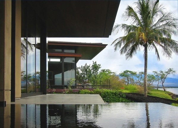 Large retractable glass doors disappear to allow the modern home to open up to the private infinity pool, beautifully lush landscaped gardens, and sparkling ocean view to the horizon. The slide-away walls also facilitate natural gentle cooling of the home, utilizing the refreshing sea breeze.