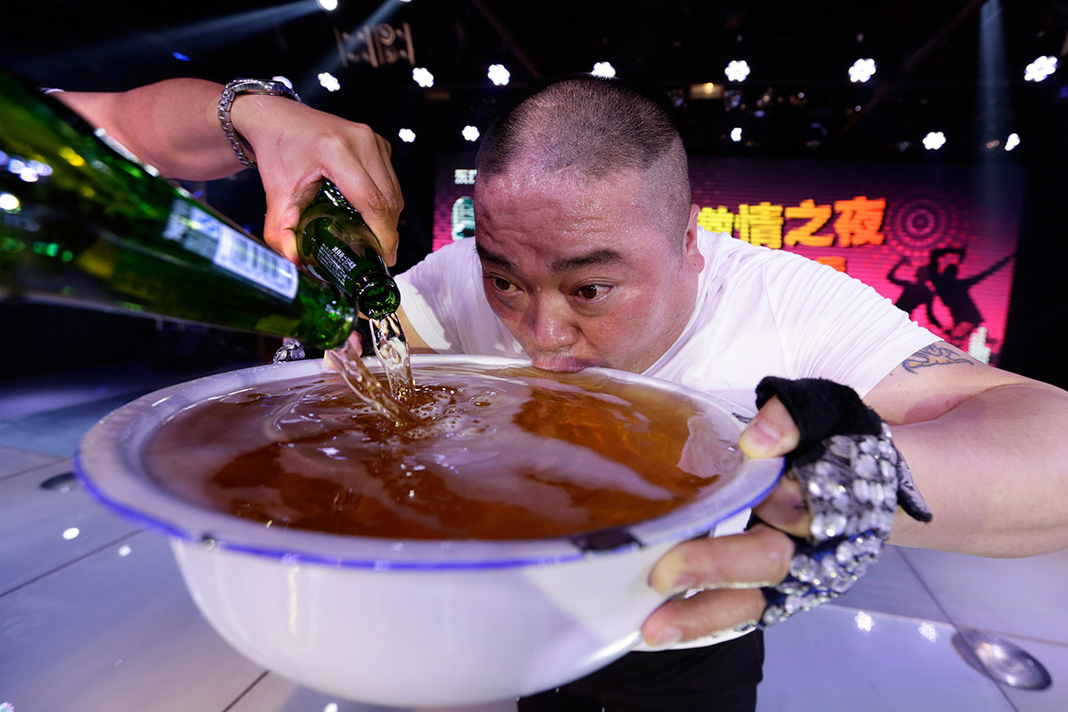 A singer drinks from a bowl of beer on-stage after performing at a club in Beijing.