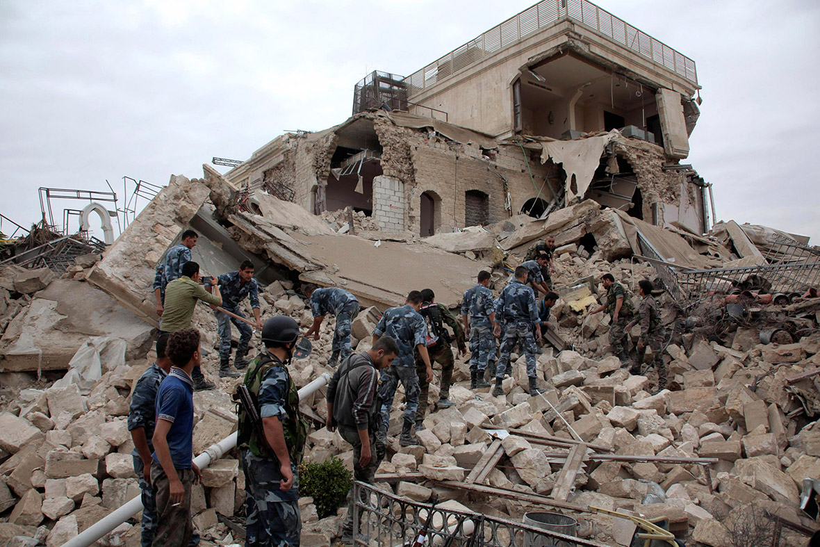 Forces loyal to Syria's President Bashar al-Assad search for survivors under the debris at a hotel used by Assad's forces, in Aleppo. Rebels detonated a huge bomb underneath the Aleppo hotel, destroying it and damaging other buildings on the edge of the city's medieval citadel