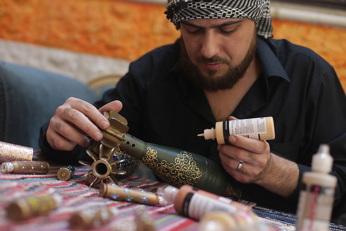Akram Sweidan decorates a mortar shell in the Duma neighbourhood of Damascus, Syria