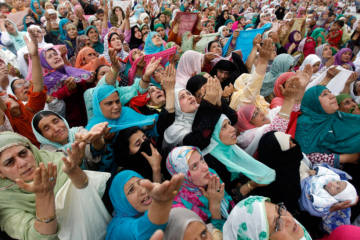 Kashmiri Muslim women raise their hands upon seeing what is believed to be a relic from the beard of Prophet Muhammad during Meraj-un-Nabi celebrations at the Hazratbal Shrine in Srinagar