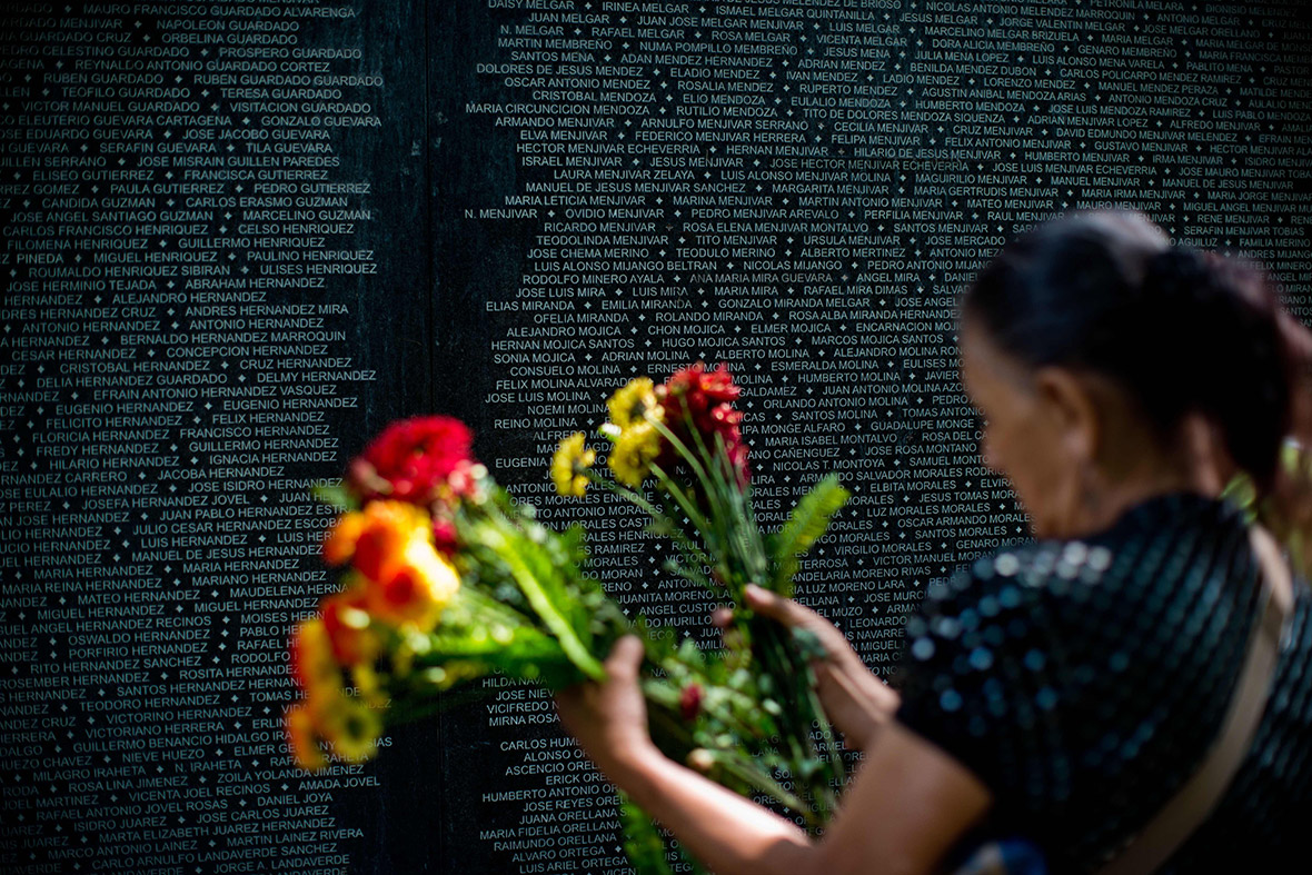 Maria Martinez de Sanchez lays flowers at the monument to people who disappeared during El Salvador's 1979-1992 civil war, at Cuscatlan Park in San Salvador