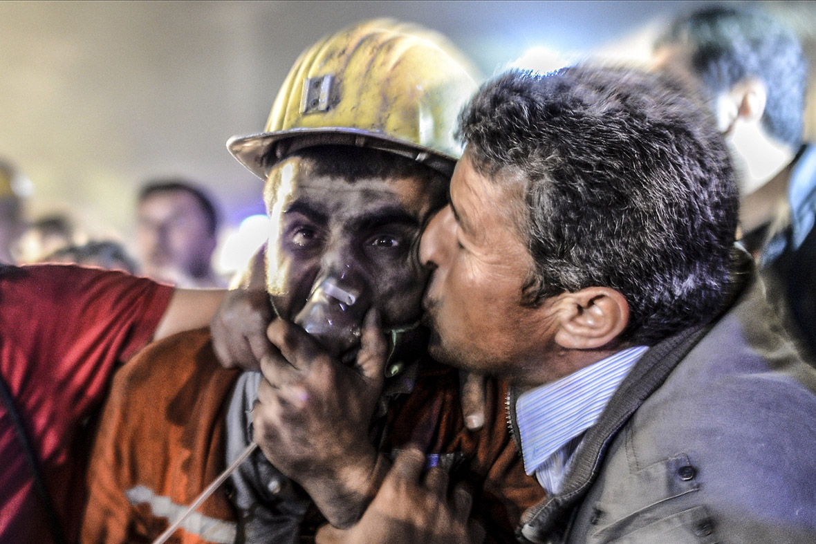 A man kisses his son after he was rescued from the mine