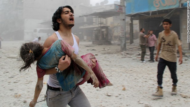 A man carries a girl injured in a reported barrel-bomb attack by Syrian government forces in Aleppo on June 3.
