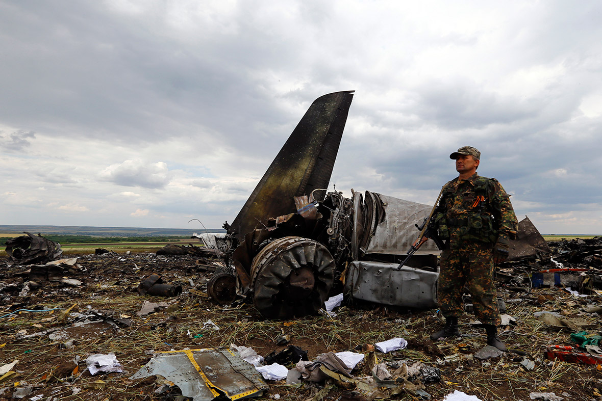 An armed pro-Russian separatist stands guard at the site of the crash of the Il-76 Ukrainian army transport plane in Luhansk. Pro-Russian separatists an anti-aircraft missile to shoot down the Ukrainian army transport plane, killing all 49 military personnel on board.
