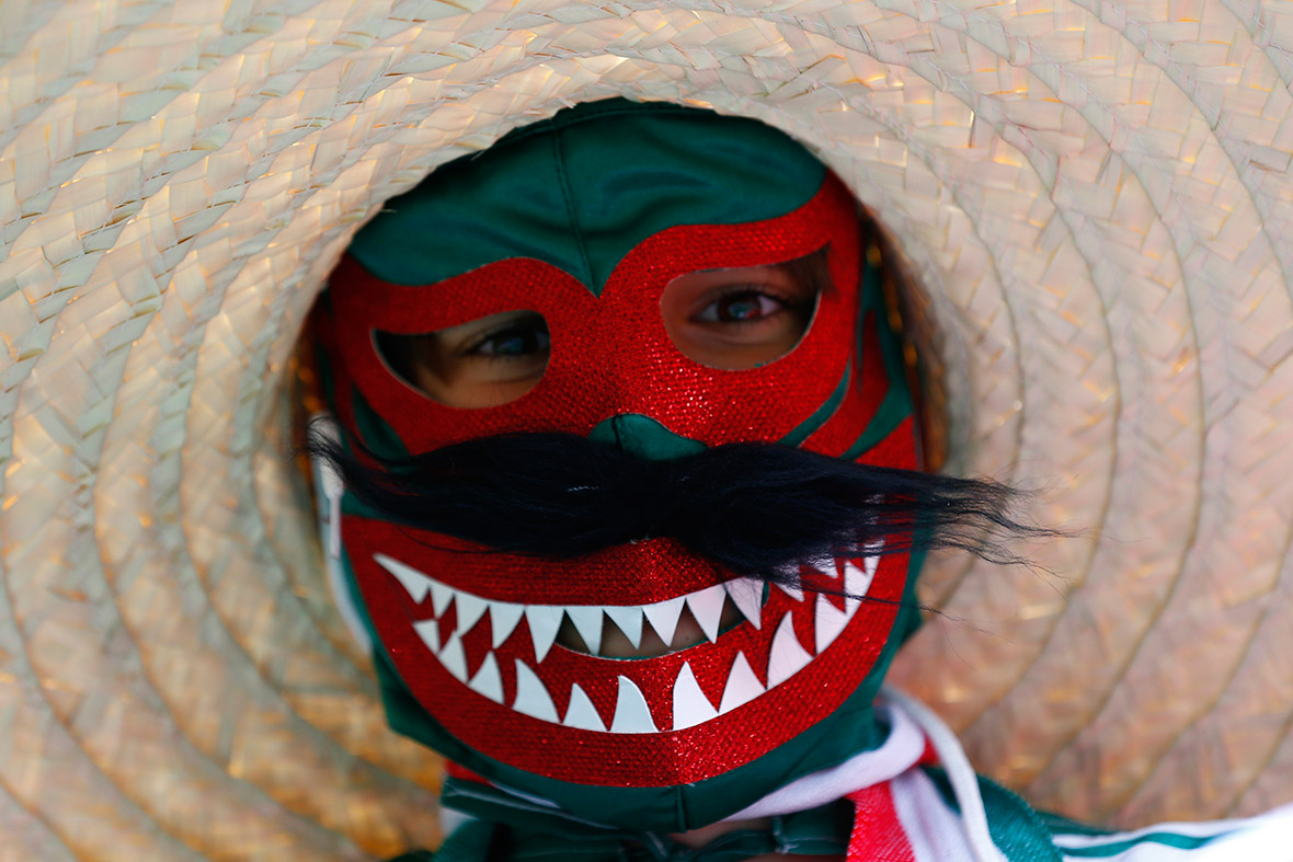 A masked Mexican fan waits for the start of their 2014 World Cup Group A match against Croatia in Recife