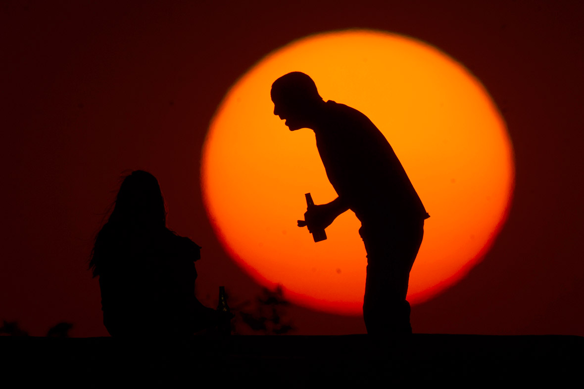 A couple chat and drink beer during sunset in Brasilia, Brazil