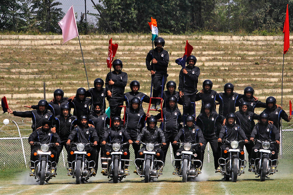 Kashmiri policemen perform a motorbike stunt during India's Independence Day celebrations in Srinagar