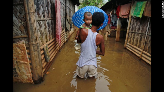 A man carries his son through floodwaters in Gauhati, India, on Friday, September 5.