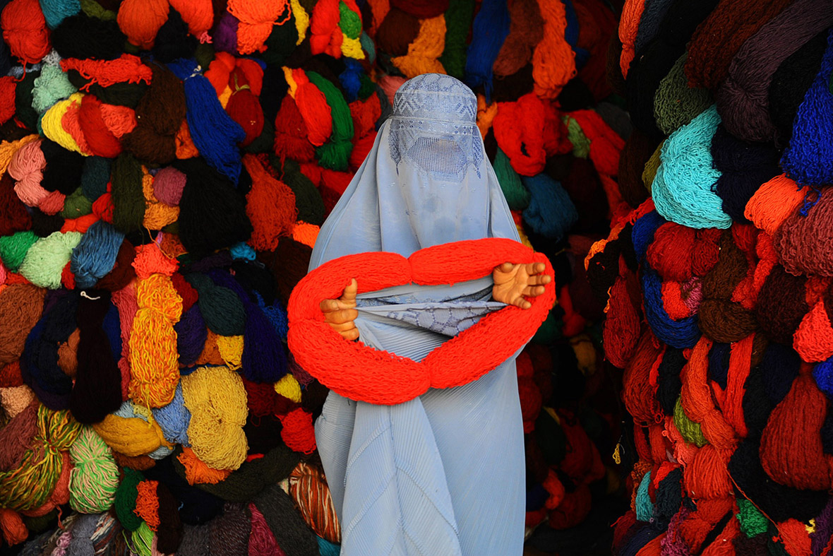 An Afghan woman buys silk yarn for weaving from a shop in Herat, once a stop along the Silk Road trade route