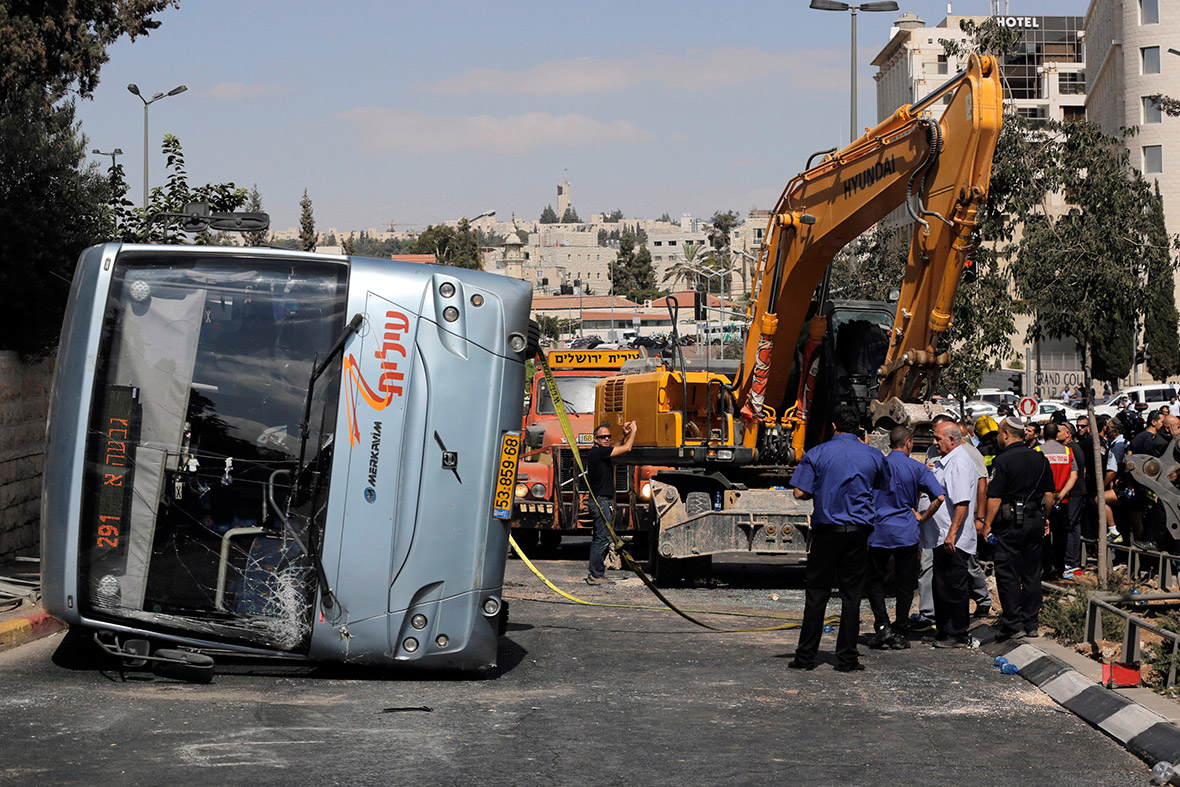 An overturned bus lies on a road in Jerusalem. A construction vehicle hit and killed a pedestrian and overturned the bus in an attack that ended when policemen shot dead the Palestinian driver of the digger