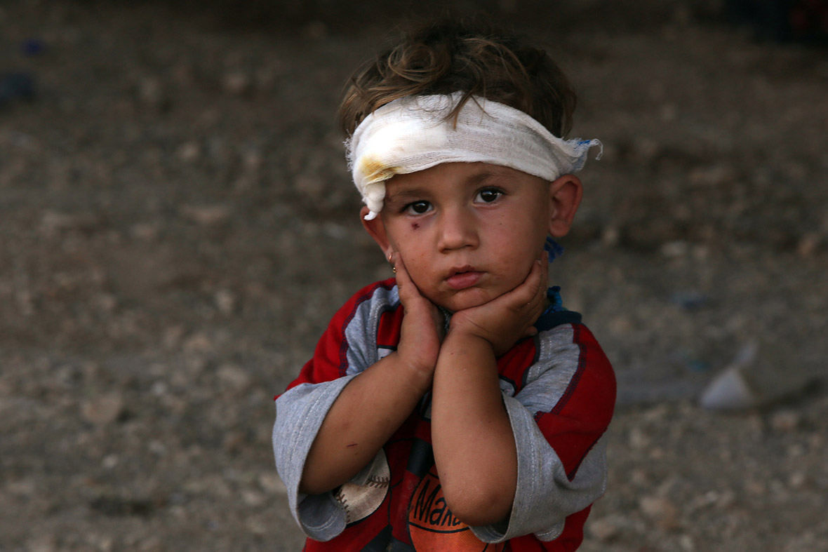 An Iraqi Yazidi child, whose family fled their home a week ago when Islamic State (IS) militants attacked the town of Sinjar, looks on at a makeshift shelter in the Kurdish city of Dohuk