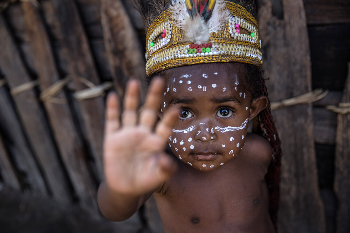 A child from the Dani tribe waves at Obia Village in Wamena, Papua, Indonesia