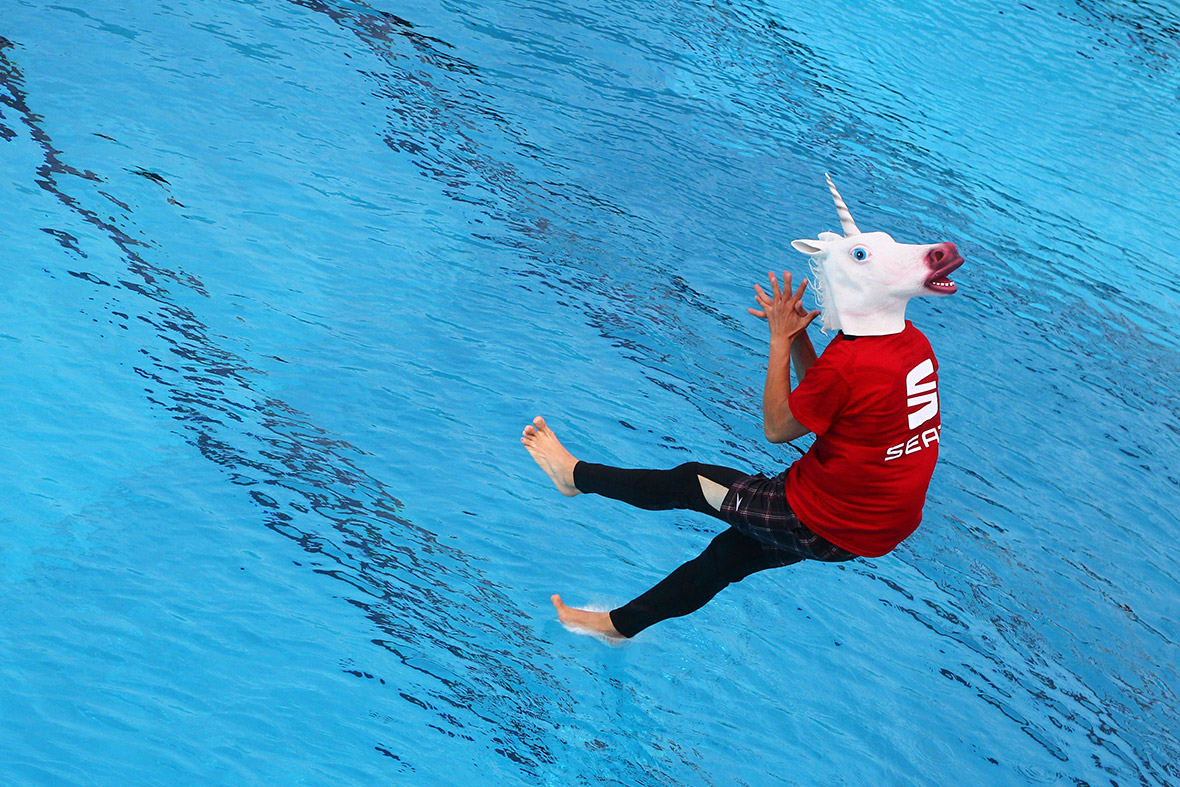 A competitor wearing a unicorn mask jumps into the Freizeitbad Silvana public swimming pool in Schweinfurt, southern Germany, during the Splashdiving World Championship