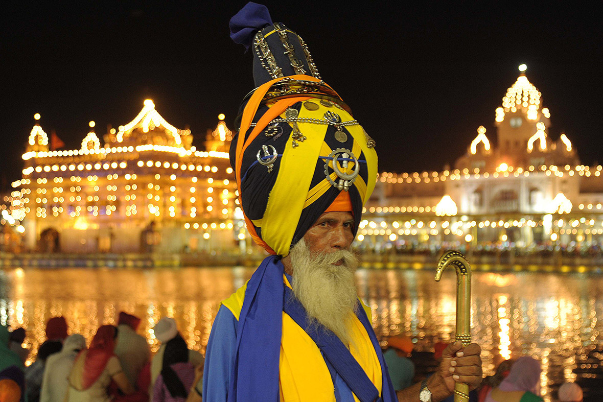 A Nihang, or Sikh warrior, poses at the Golden Temple in Amritsar on the 410th anniversary of the installation of the Guru Granth Sahib, the holy book of the Sikh religion