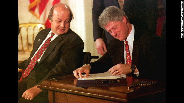 James Brady, the Reagan administration press secretary who was wounded during the 1981 assassination attempt, watches President Clinton sign the Brady Bill at the White House on November 30, 1993. The bill required a five-day waiting period for handgun purchases, ending a seven-year gun-control battle.