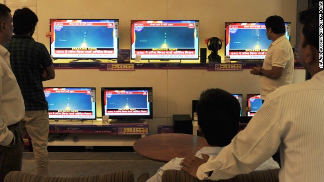 Indian bystanders watch a bank of screens showing the live telecast of the launch of India's Mars Orbiter Mission inside a showroom in New Delhi on November 5, 2013.