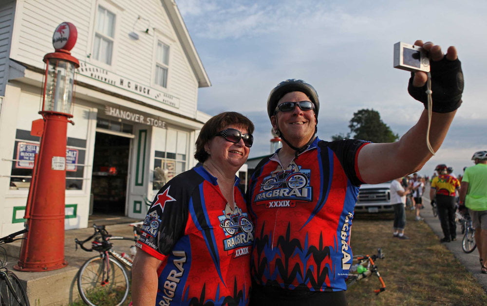 Dennis and Karen Meenen of Berthoud, Colorado, take their own photo in front of the Hanover Store at the historic Hanover Village Monday morning July 23, 2012 during RAGBRAI XL. (Rodney White/The Register)